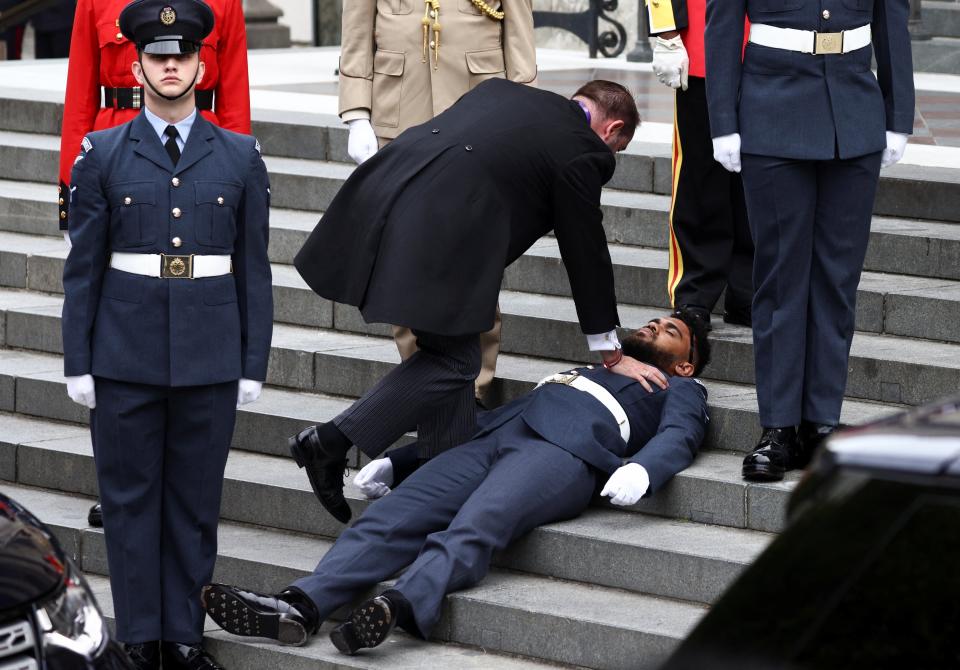Another guardsman also fainted and had to be helped away (Henry Nicholls/PA) (PA Wire)
