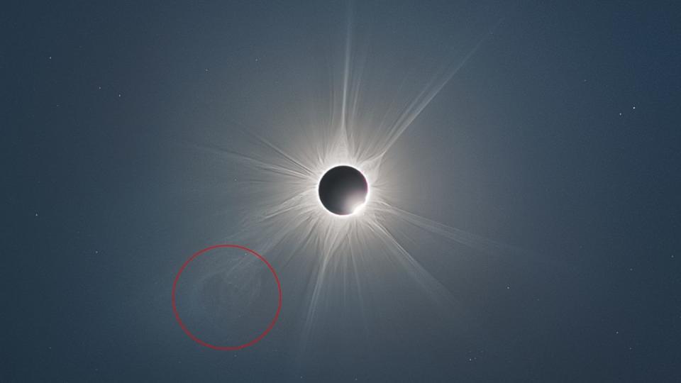 The ghostly white lines of the sun's corona shine in the darkened sky during an eclipse