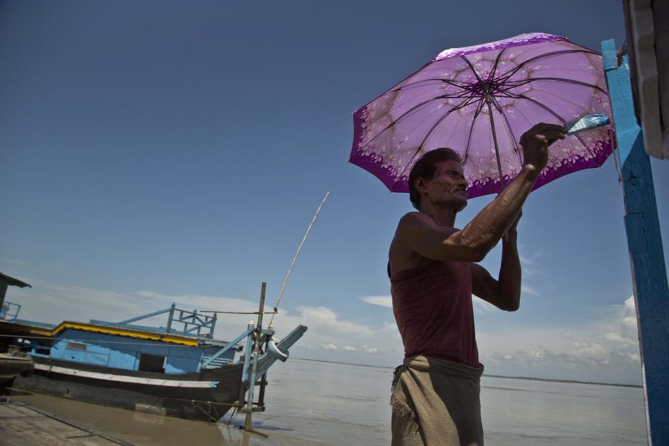 In this Aug. 7, 2018 photo, 70-year old ferry operator Betharam paints his boat on the bank of river Brahmaputra in Majuli, in the northeastern Indian state of Assam. Betharam has been witness to Majuli’s plight over many decades, seeing the Brahmaputra river change course frequently and undercutting the non-cohesive soil. Those living close to the edge of the river say part of the island is swallowed by the flood water every year, destroying their habitat and forcing people to move to the interiors and to higher ground. (AP Photo/Anupam Nath)