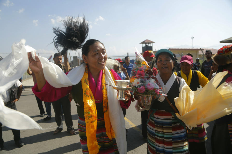Lhakpa Jungmu Sherpa, wife of Nepalese veteran Sherpa guide Kami Rita, dances at the airport in Kathmandu, Nepal, Saturday, May 25, 2019. The Sherpa mountaineer who extended his record for successful climbs of Mount Everest with his 24th ascent of the world's highest peak on Tuesday returned to Kathmandu on Saturday. (AP Photo/Niranjan Shrestha)