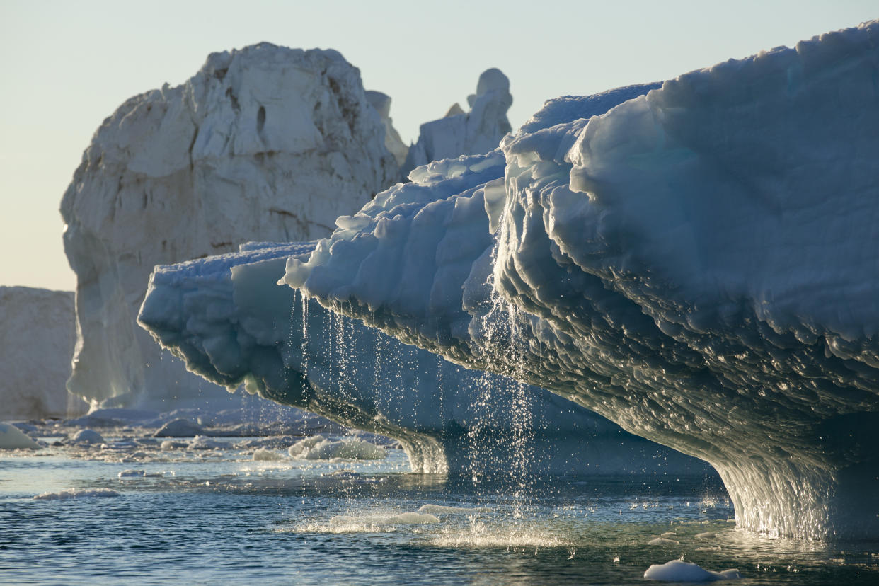 Massive icebergs from Jakobshavn Glacier melting in Disko Bay on sunny summer evening, Ilulissat, Greenland.