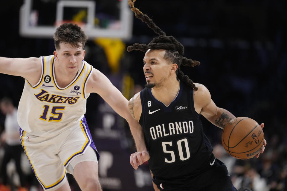 Orlando Magic guard Cole Anthony (50) dribbles past Los Angeles Lakers guard Austin Reaves (15) during the second half of an NBA basketball game Sunday, March 19, 2023, in Los Angeles. (AP Photo/Marcio Jose Sanchez)