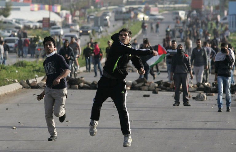 Palestinian protestors hurl stones towards Israeli security forces during clashes at the entrance of the Jalama checkpoint, near the West Bank city of Jenin, on February 24, 2013. Israel demanded Palestinian leaders quell unrest as protests and clashes rocked the West Bank on Sunday, after the death of a prisoner who the Palestinians claim died under Israeli torture