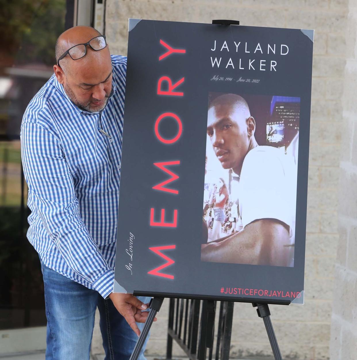 A member of the legal team representing the family of Jayland Walker places a photo of Walker outside the door at St. Ashworth Temple Church of God in Christ before a press conference on Monday in Akron.