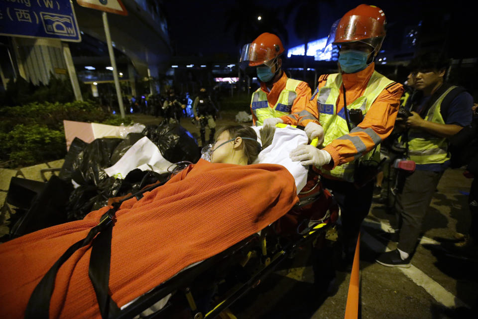 Medical workers transport an injured protester on a stretcher near Hong Kong Polytechnic University in Hong Kong, Tuesday, Nov. 19, 2019. A small band of anti-government protesters, their numbers diminished by surrenders and failed escape attempts, remained holed up at a Hong Kong university early Wednesday as they braced for the endgame in a police siege of the campus. (AP Photo/Achmad Ibrahim)