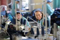 Workers produce clothes in a factory in Huaibei, east China's Anhui province on May 19, 2015