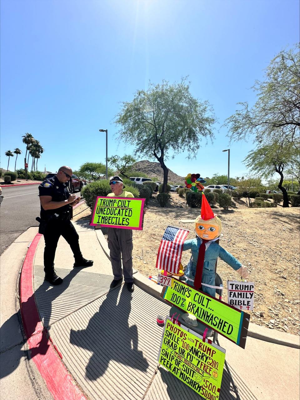 Maricopa resident Jeff Northrup protests Donald Trump outside the Dream City Church where the former president will hold a town hall later.