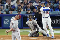 Los Angeles Dodgers' Trayce Thompson, right, hits a three-run home run as Arizona Diamondbacks relief pitcher Kevin Ginkel, left, watches along with catcher Gabriel Moreno, second from left, and home plate umpire John Tumpane during the fifth inning of a baseball game Saturday, April 1, 2023, in Los Angeles. (AP Photo/Mark J. Terrill)
