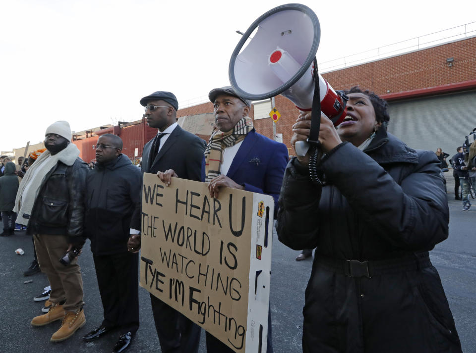 U.S. Rep. Yvette Clarke, D-New York, far right, stands beside Brooklyn Borough President Eric Adams, uses a megaphone to amplify her voice so prisoners can hear her, as the pair joined family members, protesters, and activists holding a vigil outside the Metropolitan Detention Center, Sunday, Feb. 3, 2019, in New York. Prisoners have been without heat, hot water, electricity and sanitation due to an electrical failure since earlier in the week, including during the recent frigid cold snap. (AP Photo/Kathy Willens)