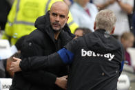 Manchester City's head coach Pep Guardiola, left, and West Ham's manager David Moyes greet each other before the start of the English Premier League soccer match between West Ham United and Manchester City at London stadium in London, Sunday, May 15, 2022. (AP Photo/Kirsty Wigglesworth)