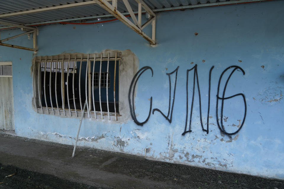 The letters “CJNG” for the group’s formal name, Jalisco New Generation Cartel, is scrawled on the facade of an abandoned home, in El Limoncito, in the Michoacan state of Mexico, Saturday, Oct. 30, 2021. The cartel based in Jalisco state is invading neighboring Michoacan, causing thousands of farmers to flee, with some seeking asylum in the United States. (AP Photo/Eduardo Verdugo)