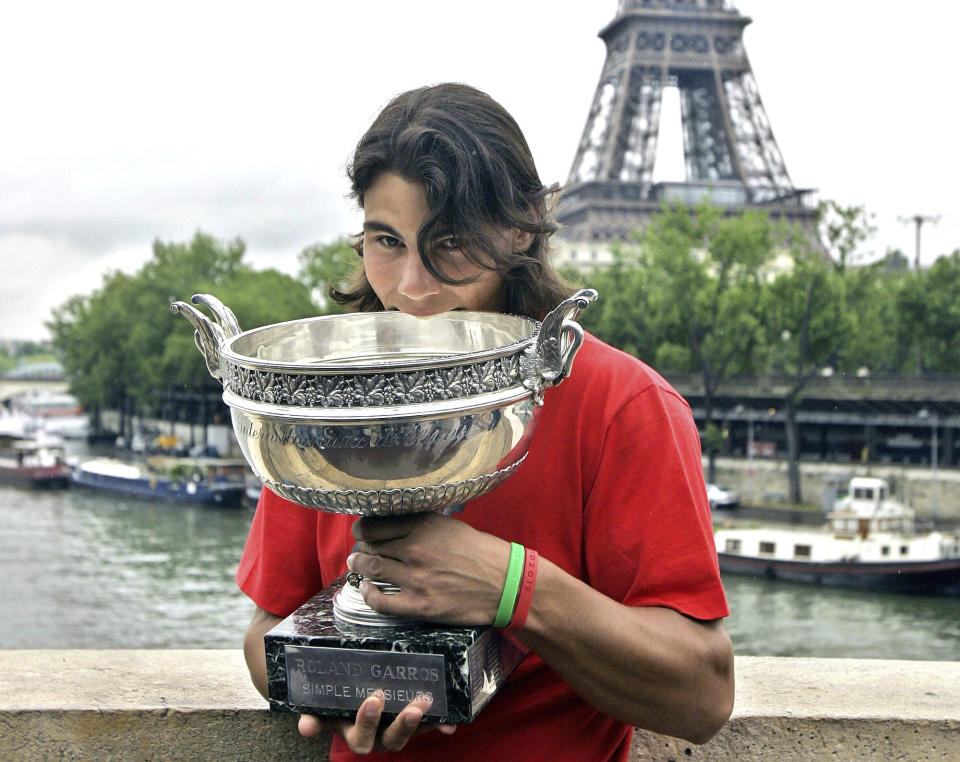 FILE - This Monday, June 6, 2005, file photo, shows Spain's Rafael Nadal posed with his trophy in front of the Eiffel tower in Paris the day after winning his first French Open championship. If Nadal manages to claim a 13th French Open championship — extending his own record for the most singles trophies won by anyone at any major tennis tournament — he would, more significantly, also collect his 20th Grand Slam title overall, tying Roger Federer’s record for a man. (AP Photo/Francois Mori, File)