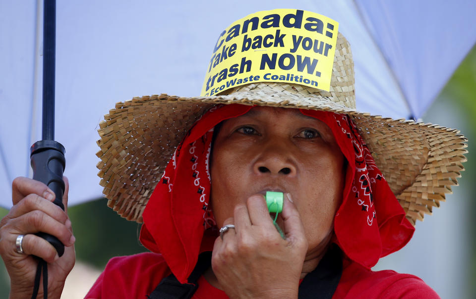 An environmentalist blows her whistle during a protest outside the Canadian Embassy to demand the Canadian government to speed up the removal of several containers of garbage that were shipped to the country Tuesday, May 21, 2019, in Manila, Philippines. The Philippines recalled its ambassador and consuls in Canada last week over Ottawa's failure to comply with a deadline to take back 69 containers of garbage that Filipino officials say were illegally shipped to the Philippines years ago. (AP Photo/Bullit Marquez)