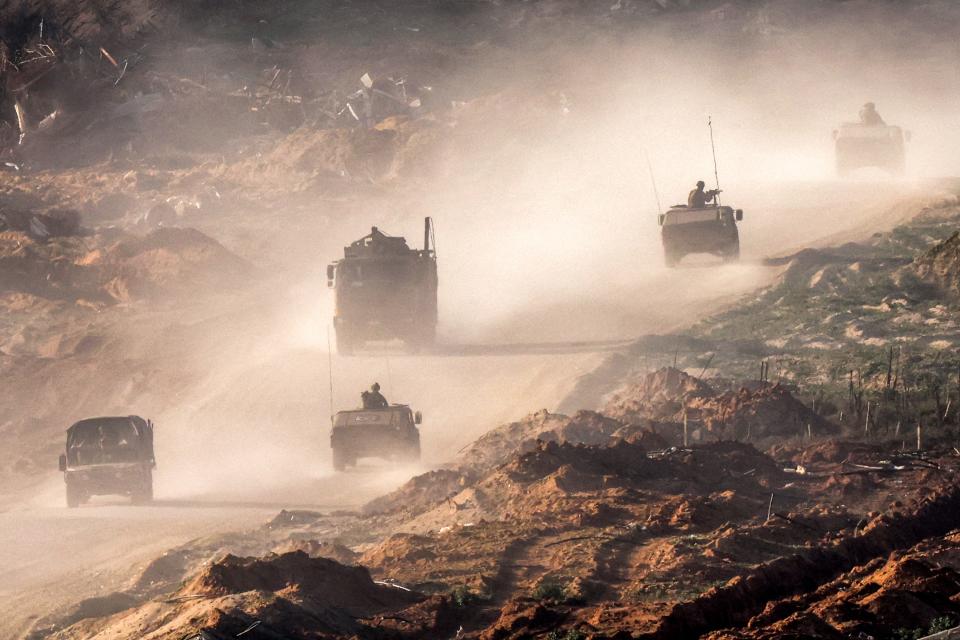 Israeli army vehicles move along a dirt road in the Gaza Strip near a position along the border with southern Israel on January 4, 2024, amid the ongoing conflict.