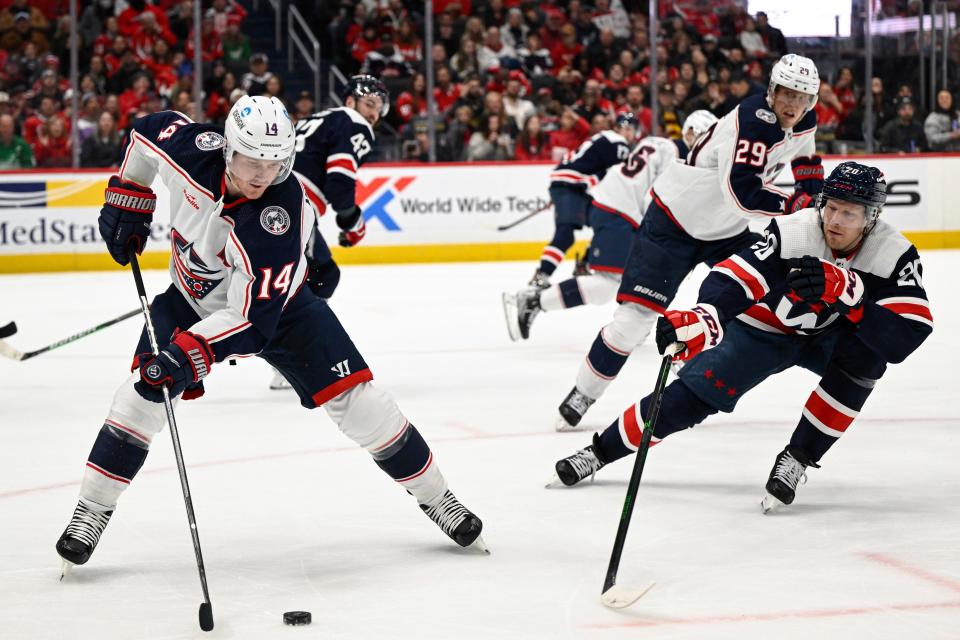 Columbus Blue Jackets left wing Gustav Nyquist (14) competes for the puck against Washington Capitals center Lars Eller (20) during the first period of an NHL hockey game, Sunday, Jan. 8, 2023, in Washington. (AP Photo/Terrance Williams)