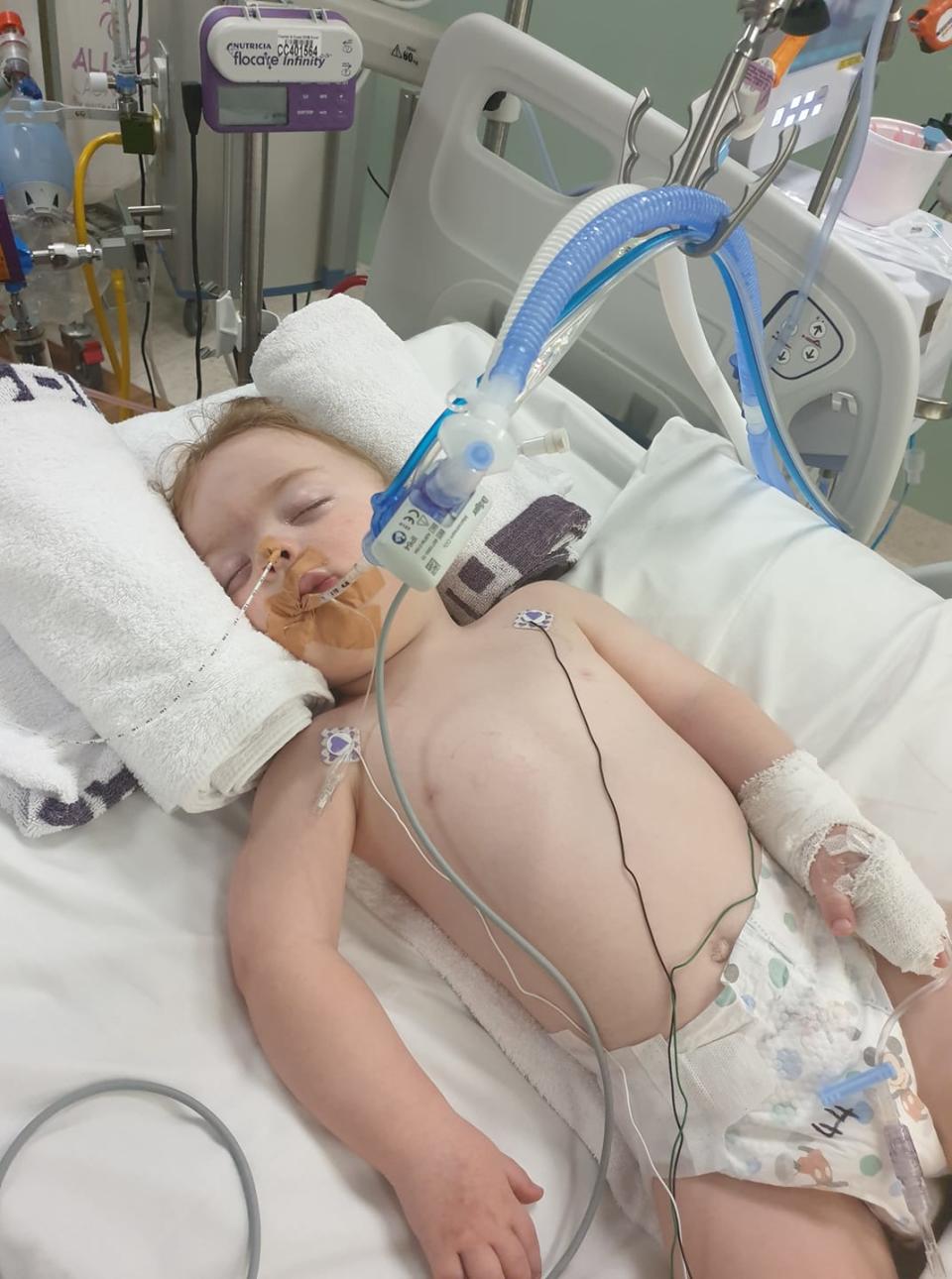 Brock shown plugged up to an oxygen machine in an Auckland hospital. His mum, Abby, has warned how deadly a simple cold can be for her son.