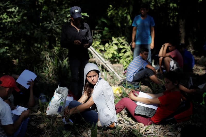 Migrants, mainly from Central America and marching in a caravan, hold forms to apply for asylum, near Frontera Hidalgo, Chiapas