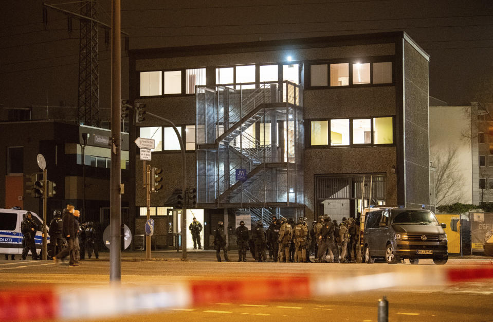 Armed police officers gather near the scene of a shooting in Hamburg, Germany on Thursday March 9, 2023. Shots were fired inside a building used by Jehovah's Witnesses in the northern German city of Hamburg on Thursday evening, and an unspecified number of people were killed or wounded, police said. (Daniel Bockwoldt/dpa via AP)