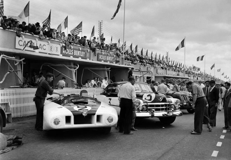 Spectators watch the final preparations in the pits of Cadillac and Rolls Bentley car makers, on June 24, 1950 before the start of the 18th edition of the 24 hours of Le Mans race, on the Le Mans racetrack. On the left, is the Cadillac number 2 "Le Monstre", on the right, the Cadillac 61 Sedan coupé de ville n°3. The first edition of the endurance race was run on May 26 and 27, 1923. The 24 hours of Le Mans 1950 took place on June 24 and 25, 1950 on the Sarthe circuit, and saw the first participation of Jaguar and Cadillac. Louis Rosier, who teamed up with his son Jean-Louis, won this 18th edition. (Photo by DUGUE / AFP)