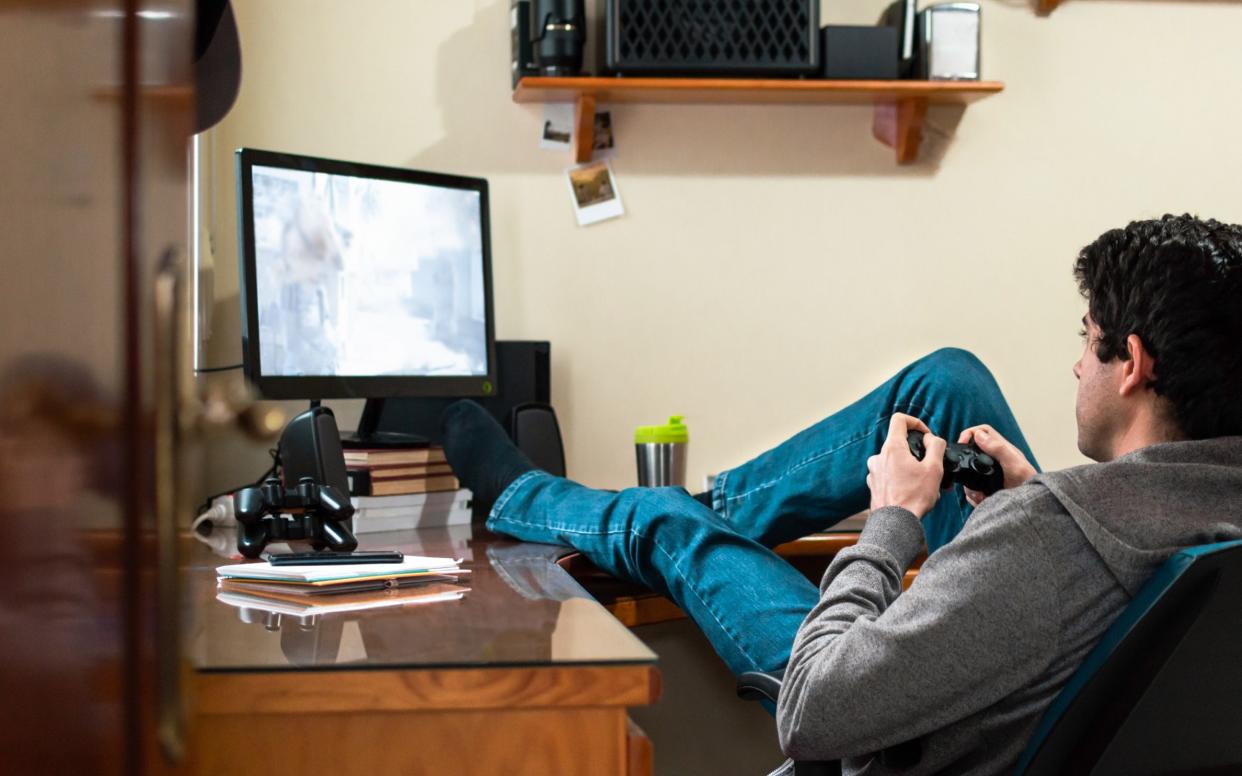 A young man plays his PlayStation 5