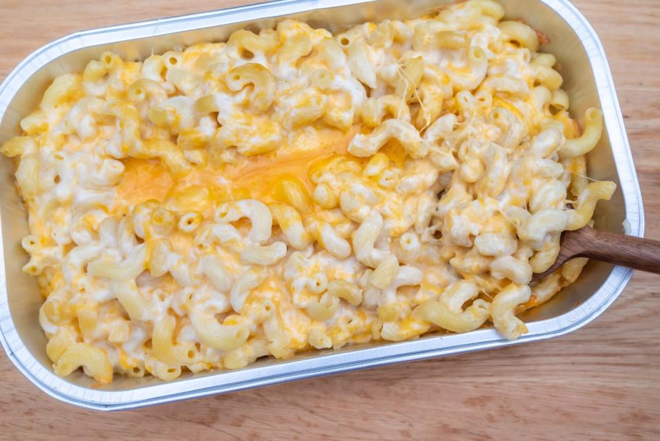 mac and cheese in container with spoon in it