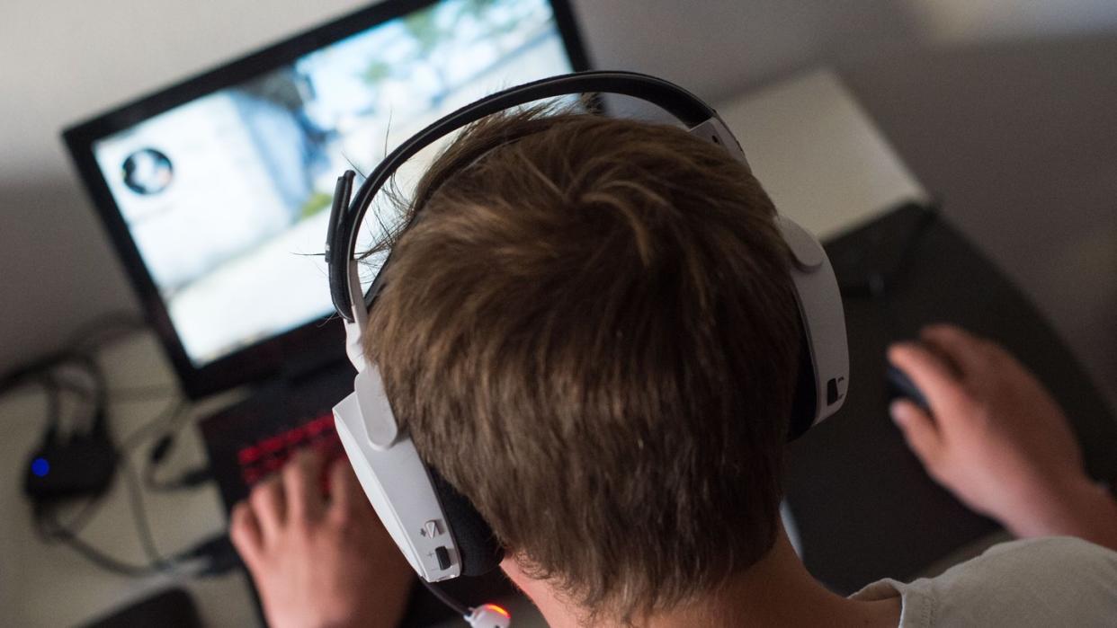 Ein junger Mann mit Headset bei einem Online-Computerspiel. Foto: Lino Mirgeler