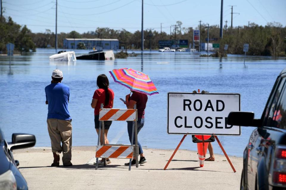 Residents wait to get supplies by boat from a section of flooded S.R. 70 in Arcadia on Sept. 30, 2022.