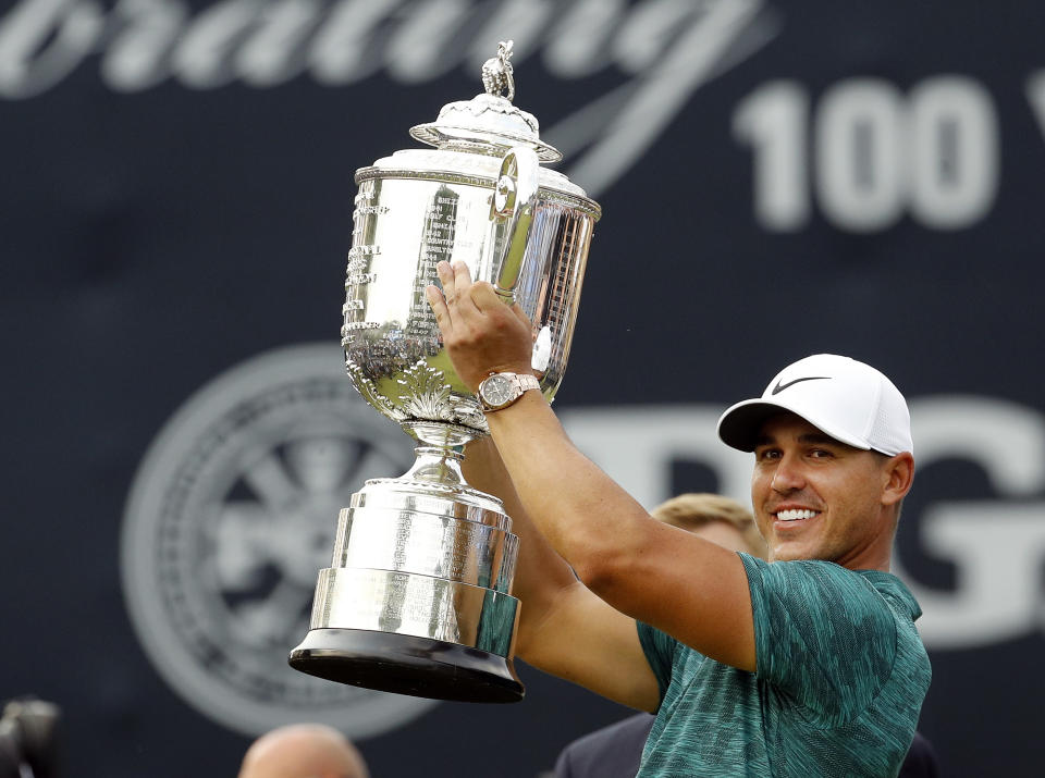 FILE - In this Aug. 12, 2018, file photo, Brooks Koepka lifts the Wanamaker Trophy after winning the PGA Championship golf tournament at Bellerive Country Club, in St. Louis. Koepka has won PGA Tour player of the year on the strength of his two major championships. (AP Photo/Charlie Riedel, File)