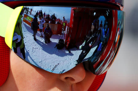 Heinz Haemmerle, or "Magic Heinzi" as US skier Lindsey Vonn calls her Austrian-born ski technician, is reflected in the ski goggles of the world's most successful skiing woman before the start of Vonn's third Olympic Downhill training run at the Winter Olympics 2018 in Pyeongchang, South Korea, February 20, 2018. REUTERS/Leonhard Foeger