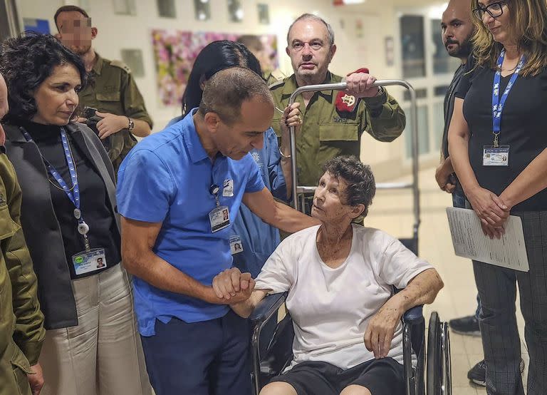 Esta fotografía proporcionada por el hospital Ichilov muestra a Yocheved Lifshitz, una de las dos mujeres liberadas del cautiverio de Hamas la noche del lunes 23 de octubre de 2023, transportada en una silla de ruedas por el pasillo del hospital de Tel Aviv, Israel. (Jenny Yerushalmy/hospital Ichilov vía AP)