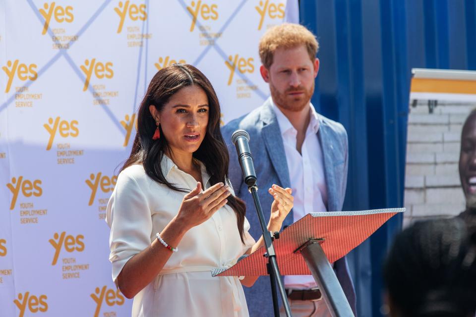 Meghan, Duchess of Sussex(L), is watched by Britain's Prince Harry, Duke of Sussex(R) as  she delivers a speech at the Youth Employment Services Hub in Tembisa township, Johannesburg, on October 2, 2019. - Meghan Markle is suing Britain's Mail On Sunday newspaper over the publication of a private letter, her husband Prince Harry has said, warning they had been forced to take action against "relentless propaganda". (Photo by Michele Spatari / AFP) (Photo by MICHELE SPATARI/AFP via Getty Images)