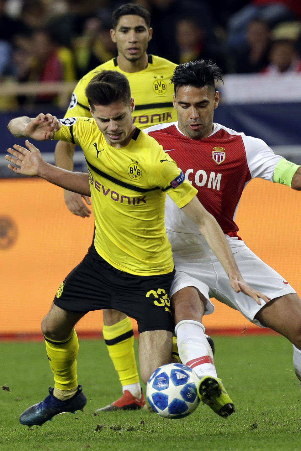 Dortmund's Julian Weigl, left, fights for the ball with Monaco forwarder Radamel Falcao during the Champions League group A soccer match between AS Monaco and Borussia Dortmund, in Monaco, Tuesday, Dec. 11, 2018. (AP Photo/Claude Paris)