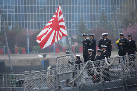 Japanese navy personnel stand next to a military flag as their Maritime Self-Defense Force destroyer JS Suzutsuki (DD 117) arrives at Qingdao Port for the 70th anniversary celebrations of the founding of the Chinese People's Liberation Army Navy (PLAN), in Qingdao, China April 21, 2019. REUTERS/Jason Lee