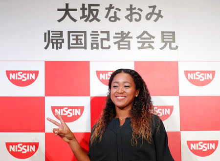 Naomi Osaka of Japan poses for photos as she attends a news conference upon her arrival in Japan, after winning the women's singles finals tennis match at the 2018 U.S. Open, in Yokohama September 13, 2018. REUTERS/Toru Hanai