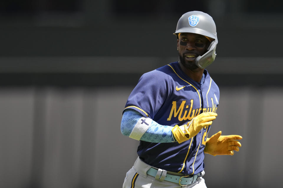 Milwaukee Brewers' Andrew McCutchen scores on a two-run home run hit by Hunter Renfroe during the seventh inning of a baseball game against the Cincinnati Reds, Sunday, June 19, 2022, in Cincinnati. (AP Photo/Jeff Dean)