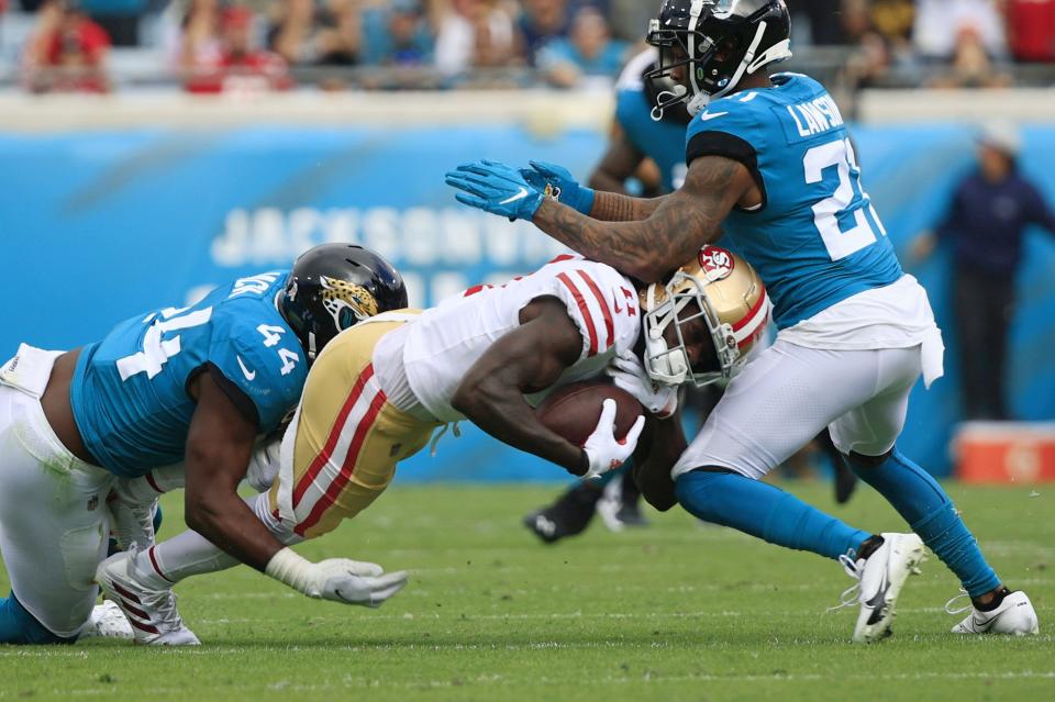 Jacksonville Jaguars linebacker Myles Jack (44) and cornerback Nevin Lawson (21) tackle San Francisco 49ers wide receiver Brandon Aiyuk (11) during the first quarter on Nov. 21.