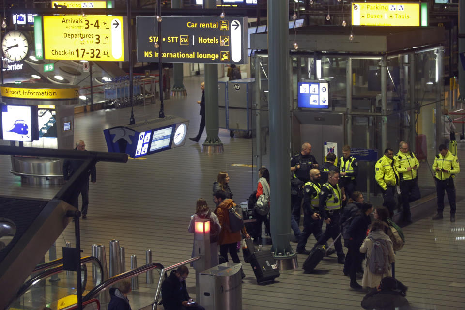 Dutch police mill about after a threat at Schiphol airport in Amsterdam, Netherlands, Wednesday, Nov. 6, 2019. Dutch military police say that all passengers and crew are safely off a plane at the center of a security alert at Amsterdam's Schiphol Airport. The military police service earlier said they were responding to a suspicious situation at the airport on the outskirts of Amsterdam. (AP Photo/Peter Dejong)