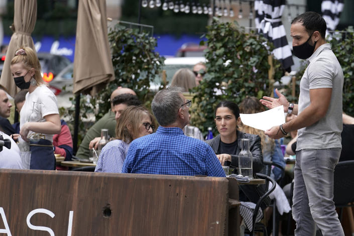 FILE - In this May 2, 2021, patrons at a sidewalk cafe are seated without masks in Boston. COVID-19 deaths in the U.S. have tumbled to an average of just over 600 per day — the lowest level in 10 months — with the number of lives lost dropping to single digits in well over half the states and hitting zero on some days. (AP Photo/Steven Senne, File)