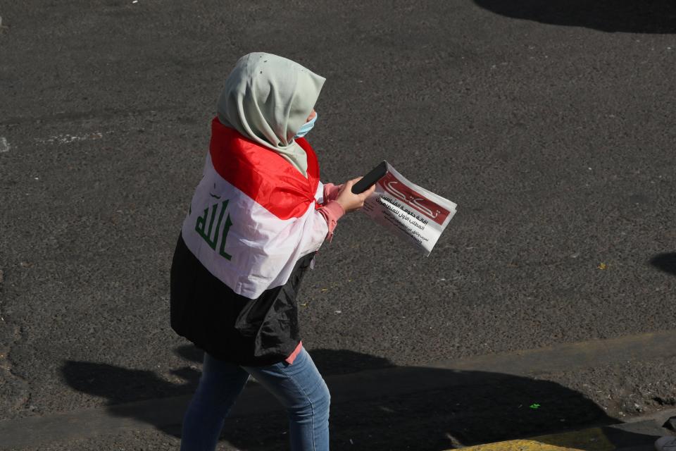 A protesters holds a copy of the "Tuk-Tuk" newspaper, in Tahrir Square, Baghdad, Iraq, Wednesday, Nov. 20, 2019. A small group of Iraqi volunteers is working in secrecy to produce the newspaper that aims to be the voice of the largest grassroots protest movement in the country’s modern history. Its editors say the newspaper is vital amid shutdowns of the internet, filling a void left by mainstream Iraqi journalists who either back the government or fear retaliation. (AP Photo/Hadi Mizban)