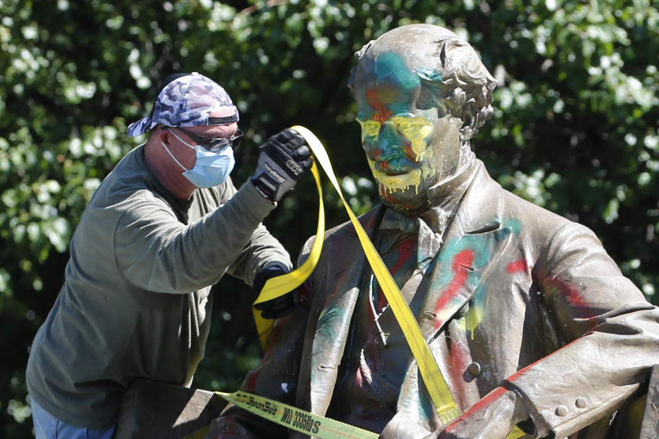 A worker secures the statue of Confederate Naval officer Matthew Fontaine Maury to a truck on Monument Avenue, Thursday, July 2, 2020, in Richmond, Va. Maury was better known for his work in oceanography and other sciences before the Civil War. His statue is the second removed since a new state law was enacted on July first. (AP Photo/Steve Helber)