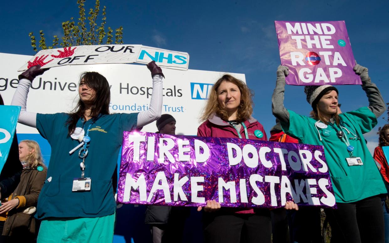 NHS workers hold up protest signs saying: Tired Doctors Make Mistakes - David Rose for The Telegraph