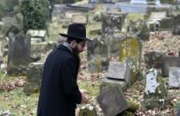 A member of the Jewish community looks at broken tombstones on February 17, 2015 following the desecration of around 300 tombs in Sarre-Union, eastern France