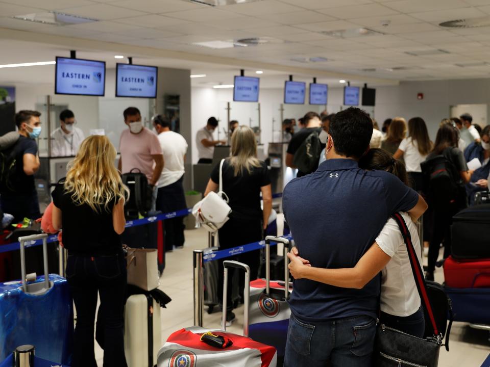 FILE - In this April 17, 2021, file photo, people check in for a flight to Miami at Silvio Pettirossi Airport, in Luque, Paraguay. Vaccine seekers who can afford to travel are coming to the United States to avoid the long wait, including people who have come from as far as Paraguay. (AP Photo/Jorge Saenz, File)