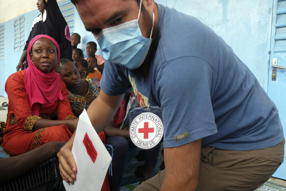 In this April 2018 photo provided by the International Commission of the Red Cross, forensic consultant Franco Mora Felix takes a DNA sample in the village of Boki Diame, Mauritania, from the relative of a missing migrant believed to have died in April 18, 2015 shipwreck in the Mediterranean Sea. (ICRC via AP)
