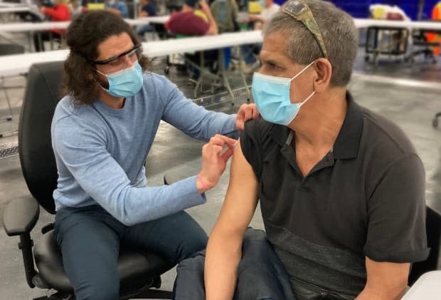 Mario Alonso Mejia Garcia, 56, receives his first COVID-19 vaccine in Edmonton in last month. Alberta is nearing the two-million vaccine doses administered mark, with the province reporting a total of 1,975,341 doses as of end of day Tuesday.  (AHS - image credit)