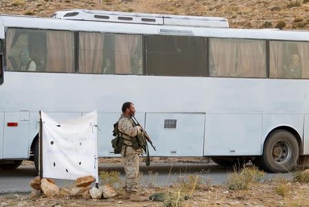 A Hezbollah fighter is seen escorting a bus in Jroud Arsal, Lebanon August 2, 2017. REUTERS/Mohamed Azakir