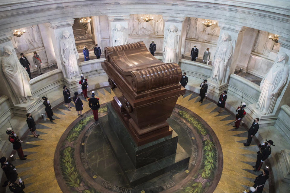 El presidente francés Emmanuel Macron y su esposa Brigitte Macron, en la parte superior, montan guardia el miércoles 5 de mayo de 2021 frente a la tumba de Napoleón Bonaparte durante una ceremonia para conmemorar el bicentenario de la muerte del emperador, en el monumento de Los Inválidos, en París. (Christophe Petit Tesson/Pool vía AP)