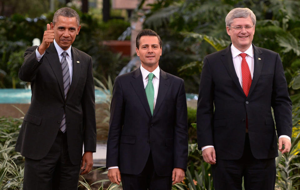 President Barack Obama, left, gives a thumbs up as he poses for photos with Mexico's President Enrique Pena Nieto, center, and Canada's Prime Minister Stephen Harper at the North American Leaders Summit in Toluca, Mexico, Wednesday, Feb. 19, 2014. The leaders met in part to highlight the economic cooperation that has grown since the North American Free Trade Agreement (NAFTA) joined the U.S., Canada and Mexico 20 years ago. (AP Photo/Canadian Press, Sean Kilpatrick)