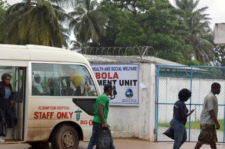 People walk on October 11, 2014 outside the Ebola Island Clinic in Monrovia