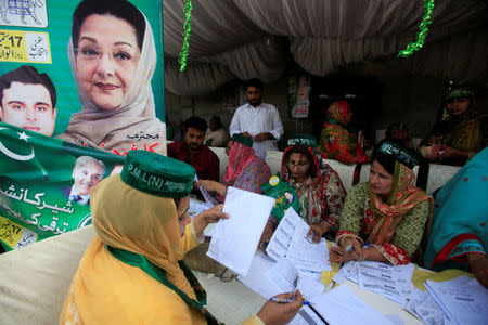 Workers of the PMLN political party guide voters and share voting lists outside a polling station in Lahore, Pakistan September 17, 2017. REUTERS/Mohsin Raza